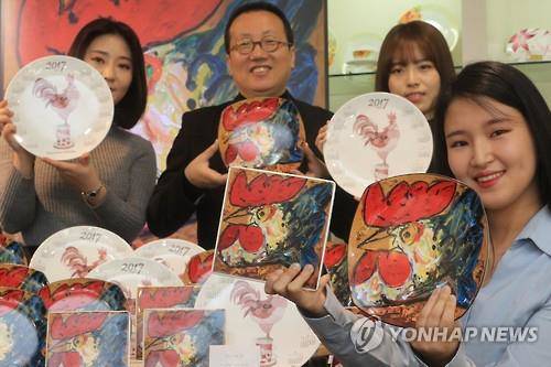 사석원 작가가 연희동 한국도자기 매장에서 작품 '왕이 된 닭'이 프린트 된 도자기를 들어보이고 있다.(사진=연합뉴스)