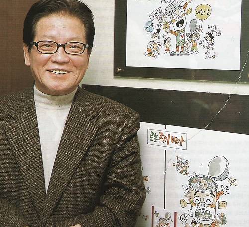 본인의 작품 '로봇찌빠'의 캐릭터가 그려진 포스터 앞에 선 신문수 작가. (사진=한국만화영상진흥원)