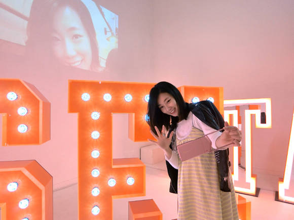 전시장에서 셀피를 즐기고 있는 관람객. 전시장에는 ‘#SELSTAR X YOU’ 영상도 함께 상영된다.(사진=김가람)