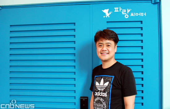 정진국 여우별컴퍼니 대표가 파랑씨어터 극장 문 앞에서 포즈를 취했다. 청량감이 느껴지는 파란색 대문이 눈길을 끈다.(사진=김금영 기자)